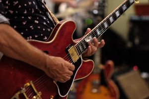 close up photo of hands playing a guitar